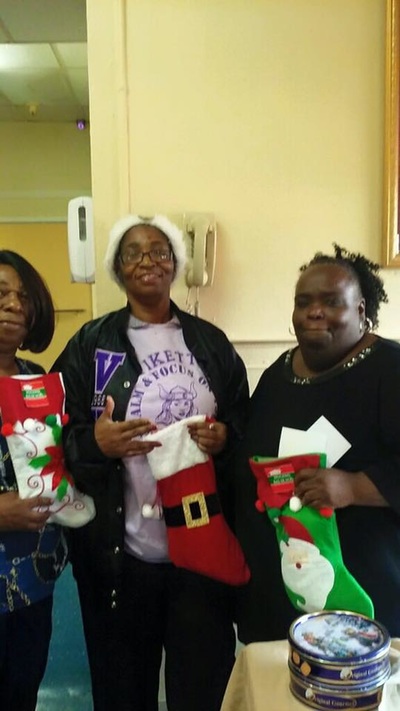 Beta Chi members holding Christmas stockings during nursing home outreach